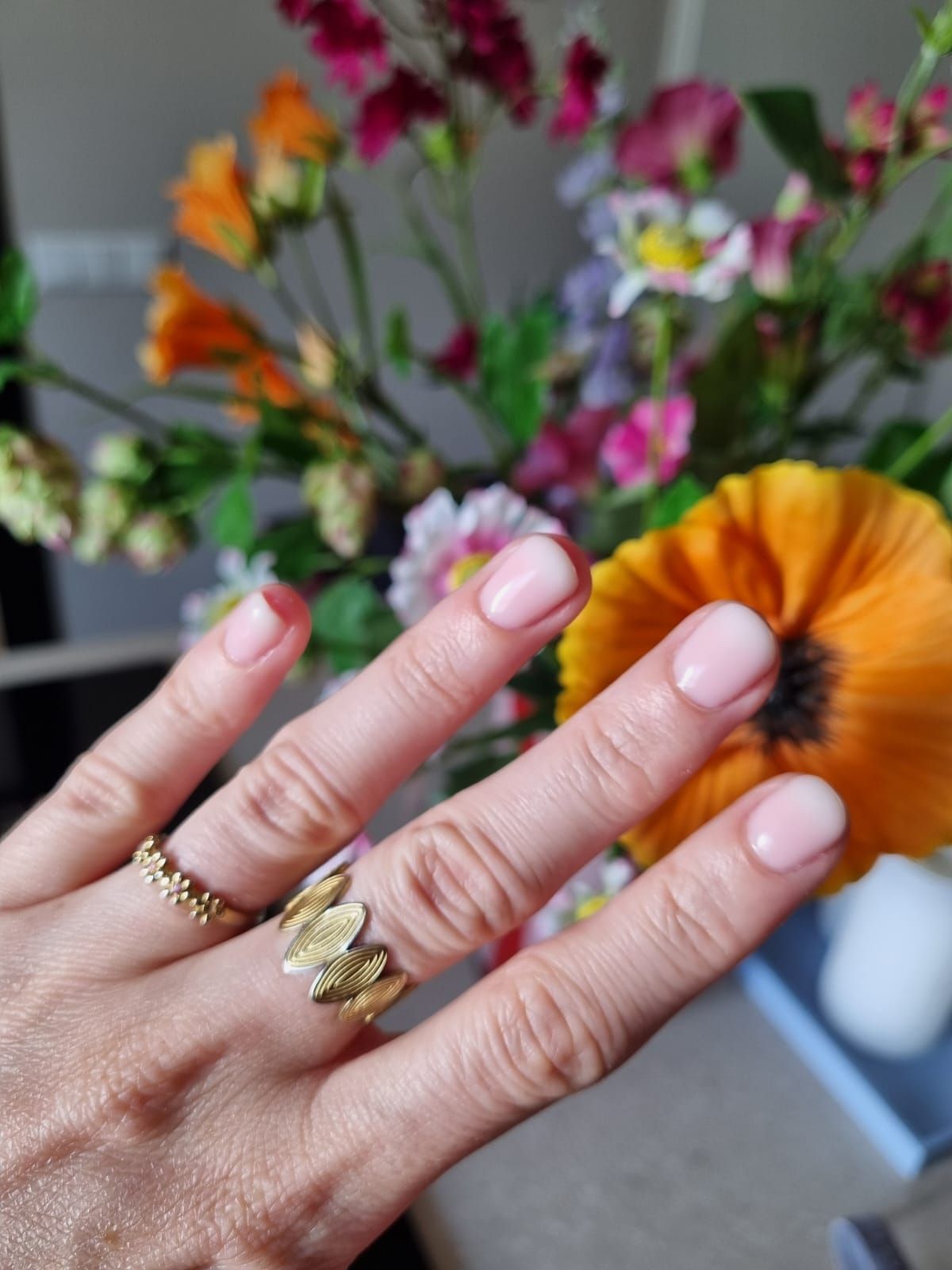Roze BIAB-nagels met gouden ringen voor kleurrijke bloemen