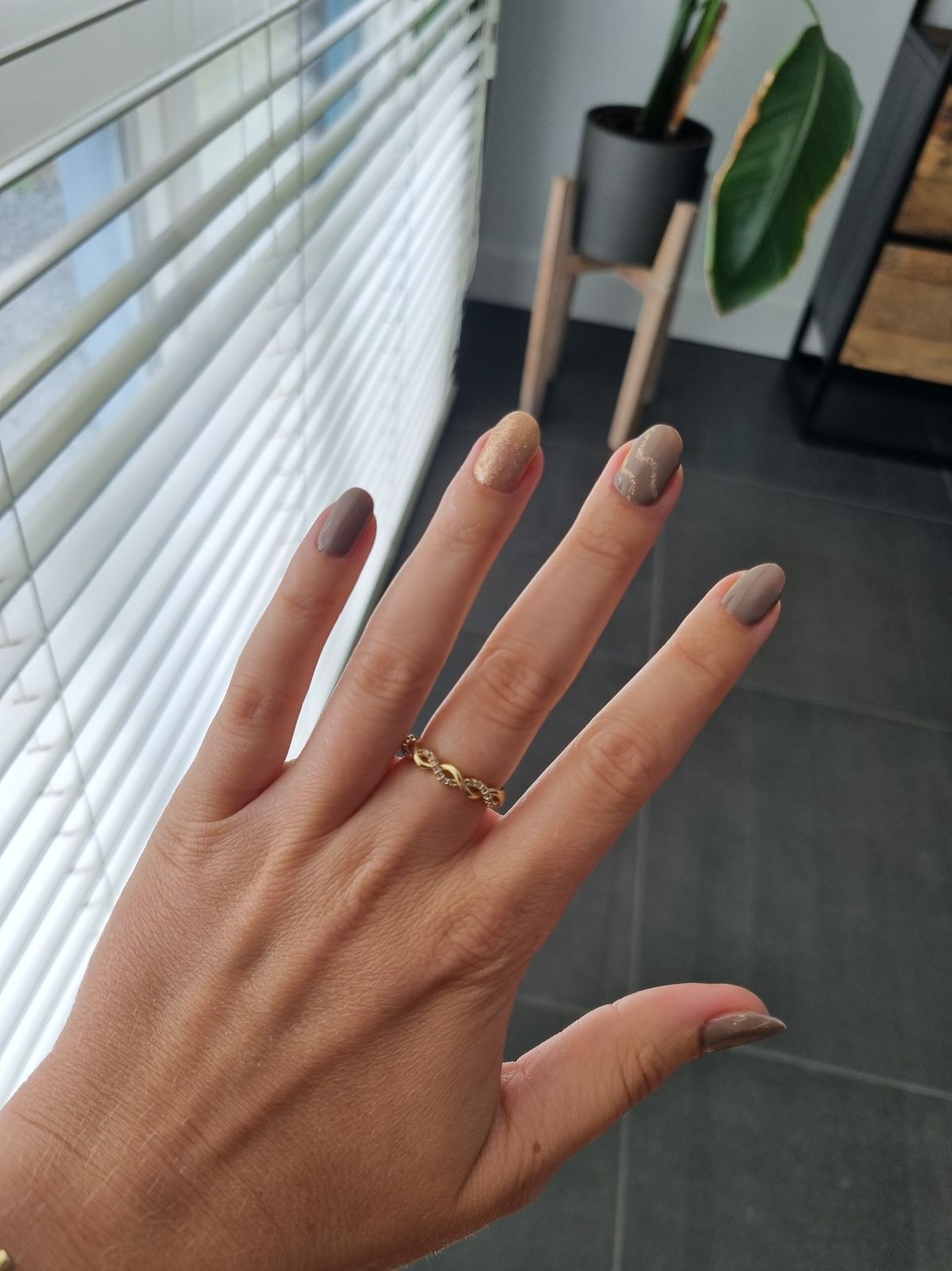 Mokkakleurige nagels met een cateye-accent en een gouden ring